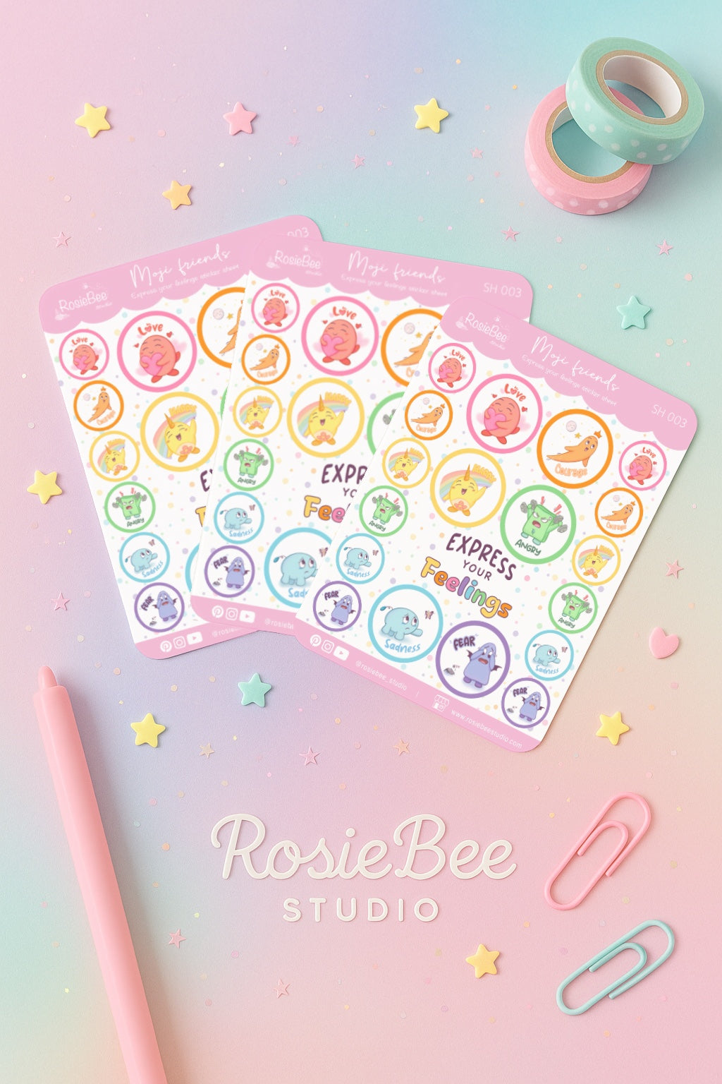 Pastel Moji Friends emotie-stickers op een B6-stickervel, gebruikt voor planners en journaling, gefotografeerd in een zachte pastel flatlay stijl met sterren en stationery.