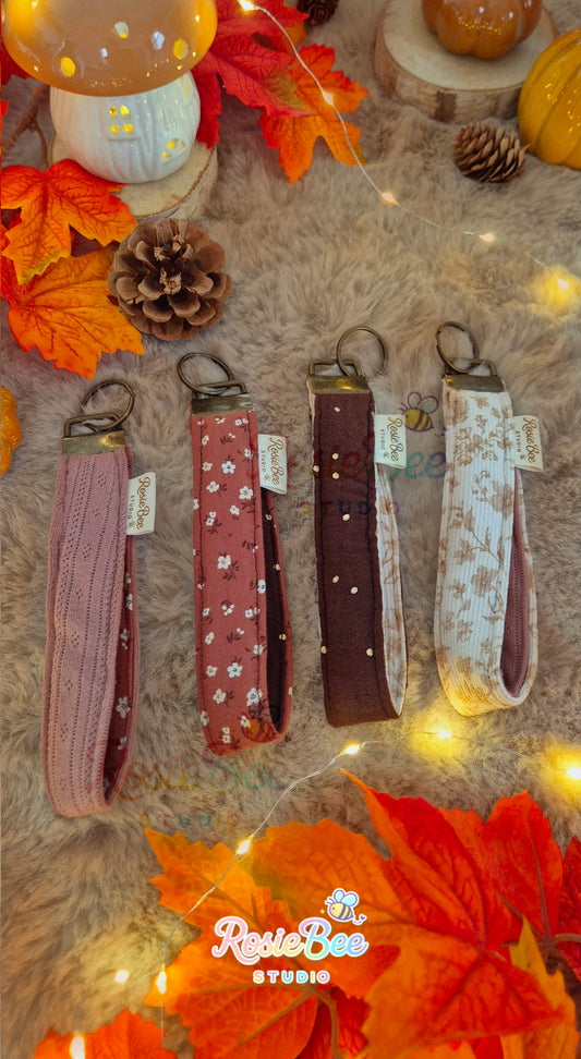 Vier handgemaakte wristlets en pols-sleutelkoorden uit de A New Chapter herfstcollectie van RosieBee Studio in verschillende stoffen, prints en warme herfstkleuren.