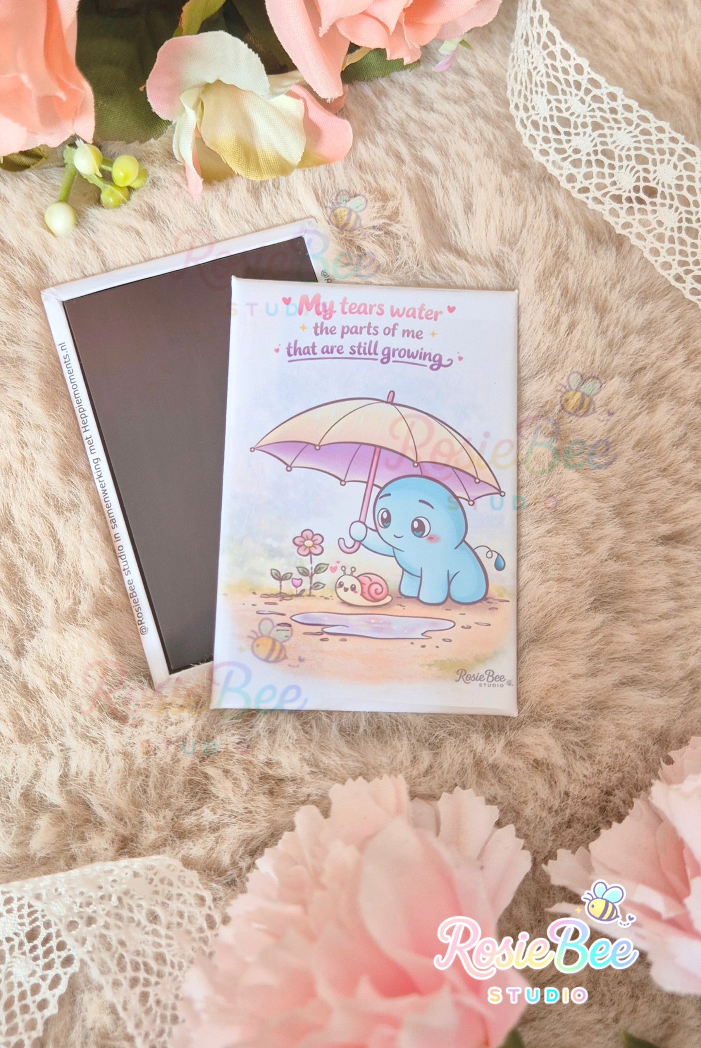 Magneet van RosieBee Studio met Moji Friend Verdriet onder een paraplu in de regen en de quote My Tears Water the Parts of Me That Are Still Growing, 78 × 53 mm.