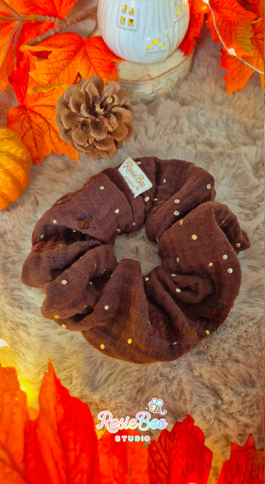 Handgemaakte Starlit Autumn scrunchie van RosieBee Studio uit de A New Chapter herfstcollectie, gemaakt van donkerbruine hydrofiel stof met gouden stipjes.