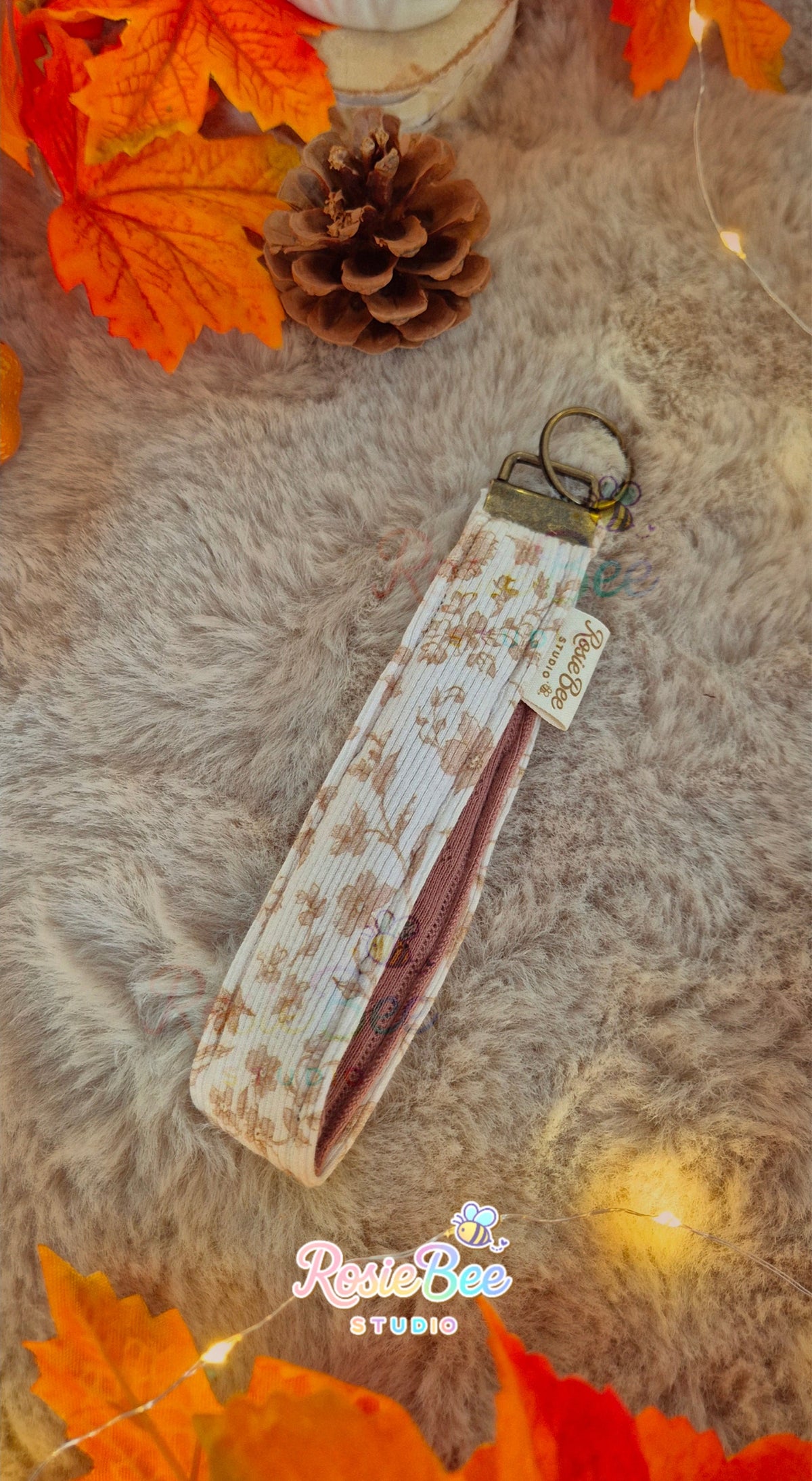 Handgemaakte Storybook Meadow wristlet van RosieBee Studio van crèmekleurige botanische rib jersey met bronskleurige metalen hardware.