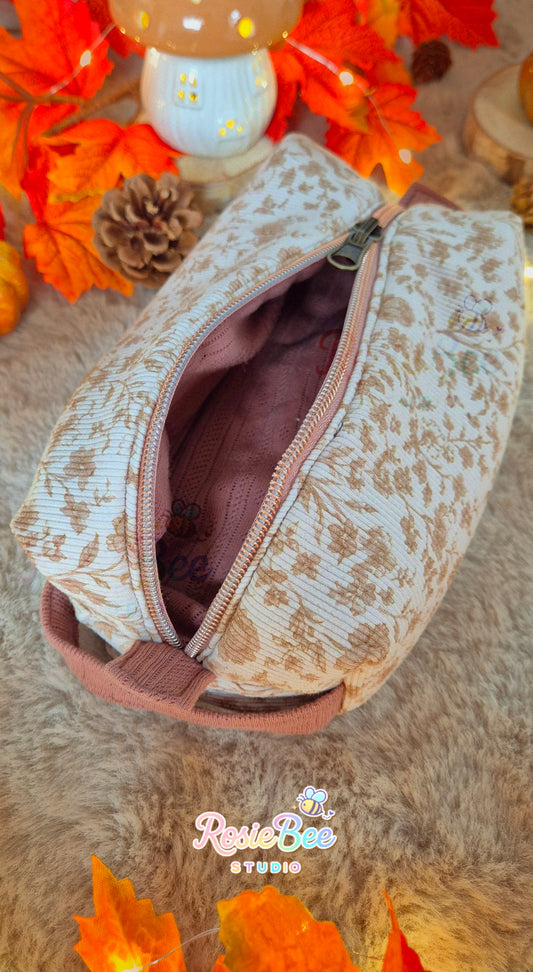 Handgemaakte Storybook Meadow reversible etui van RosieBee Studio met crèmekleurige botanische rib jersey en bronskleurige ritssluiting.
