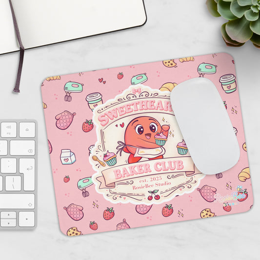 Sweetheart Baker Club pastel bakery muismat met Moji Friend Liefde illustratie op bureau naast toetsenbord en muis.  