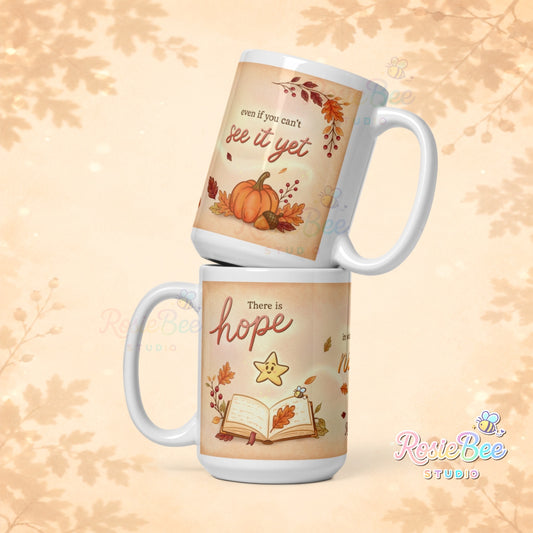 Witte mok van 440 ml uit de A New Chapter herfstcollectie van RosieBee Studio met sterretje Hoop, herfstbladeren, boek en de quote There is hope in what comes next even if you can’t see it yet.