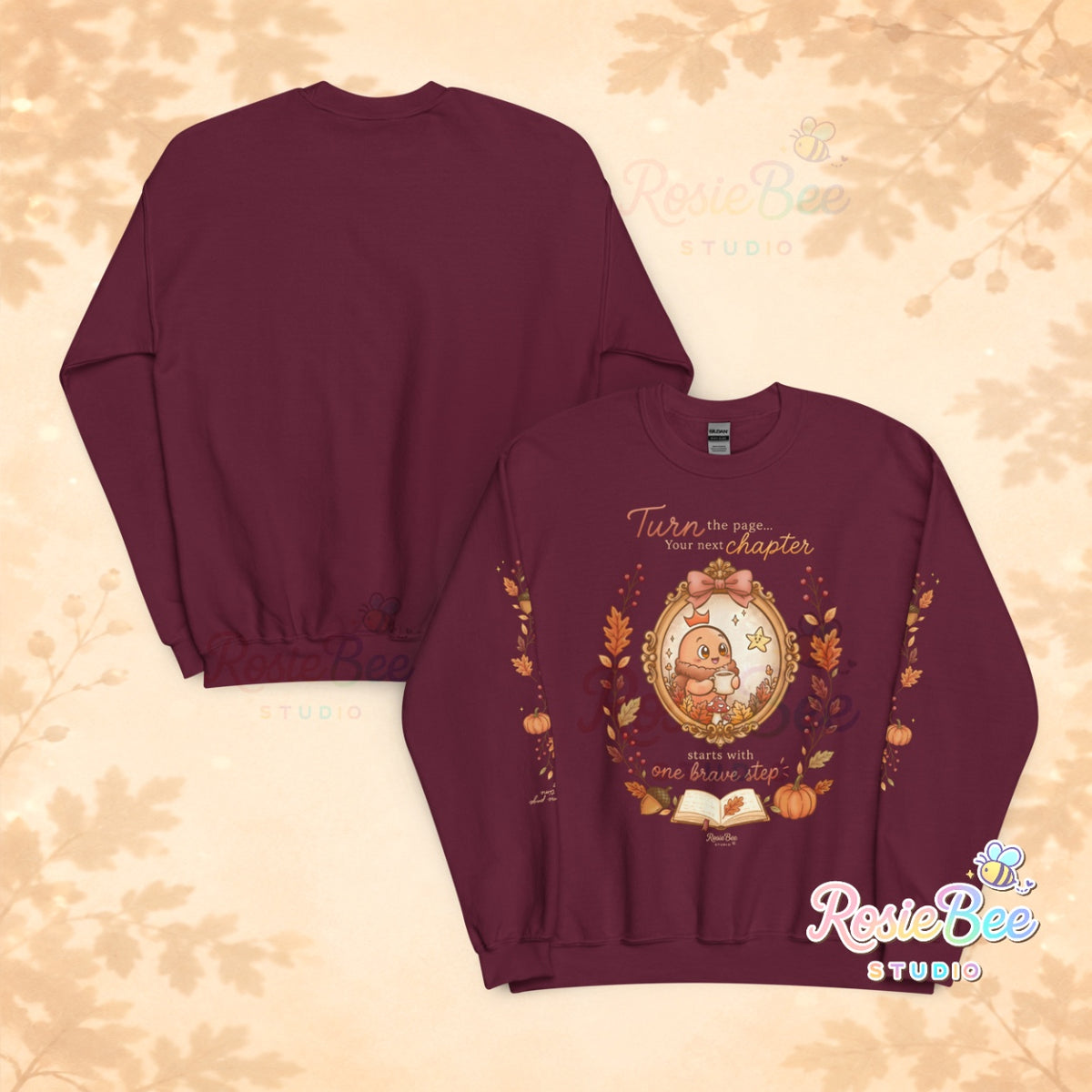 Bordeauxrode A New Chapter sweater van RosieBee Studio met Moji Friend Moed, sterretje Hoop, herfsttakken op de mouwen en de tekst take it one page at a time op de rechtermouw.